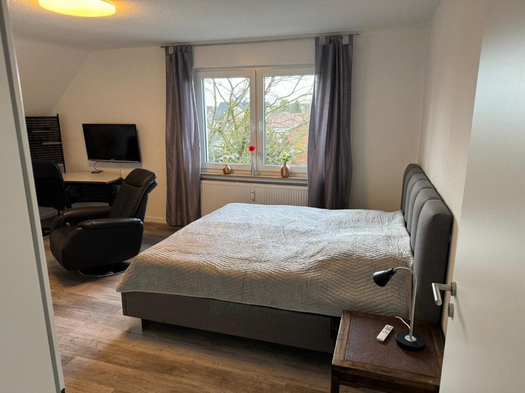 Schlafzimmer mit einem Bett, einem Schreibtisch und einem Stuhl in der Unterkunft Ferienwohnung Lippstadt in Lippstadt