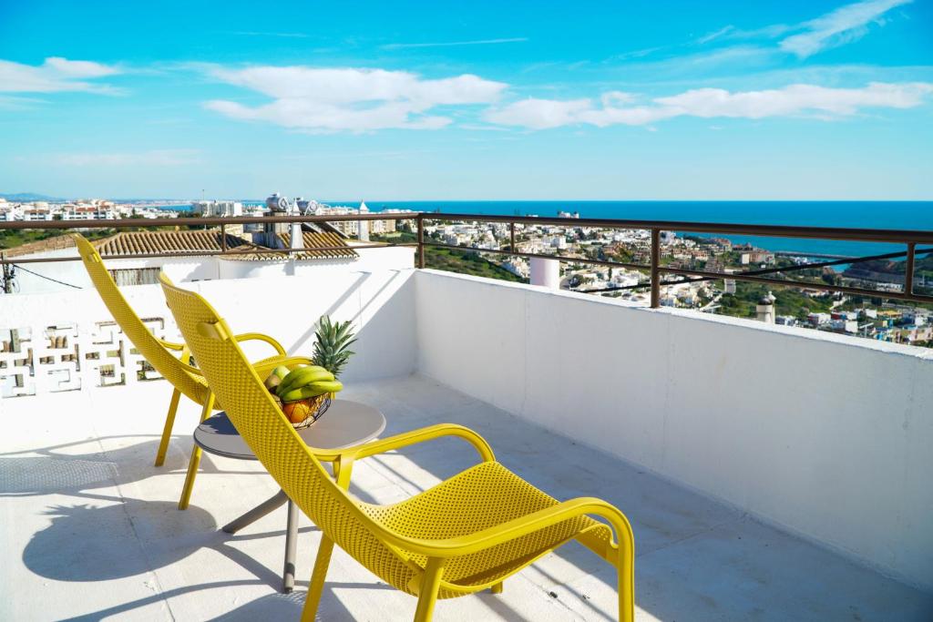 a balcony with two chairs and a table with a view at Villa Marrachinho in Albufeira
