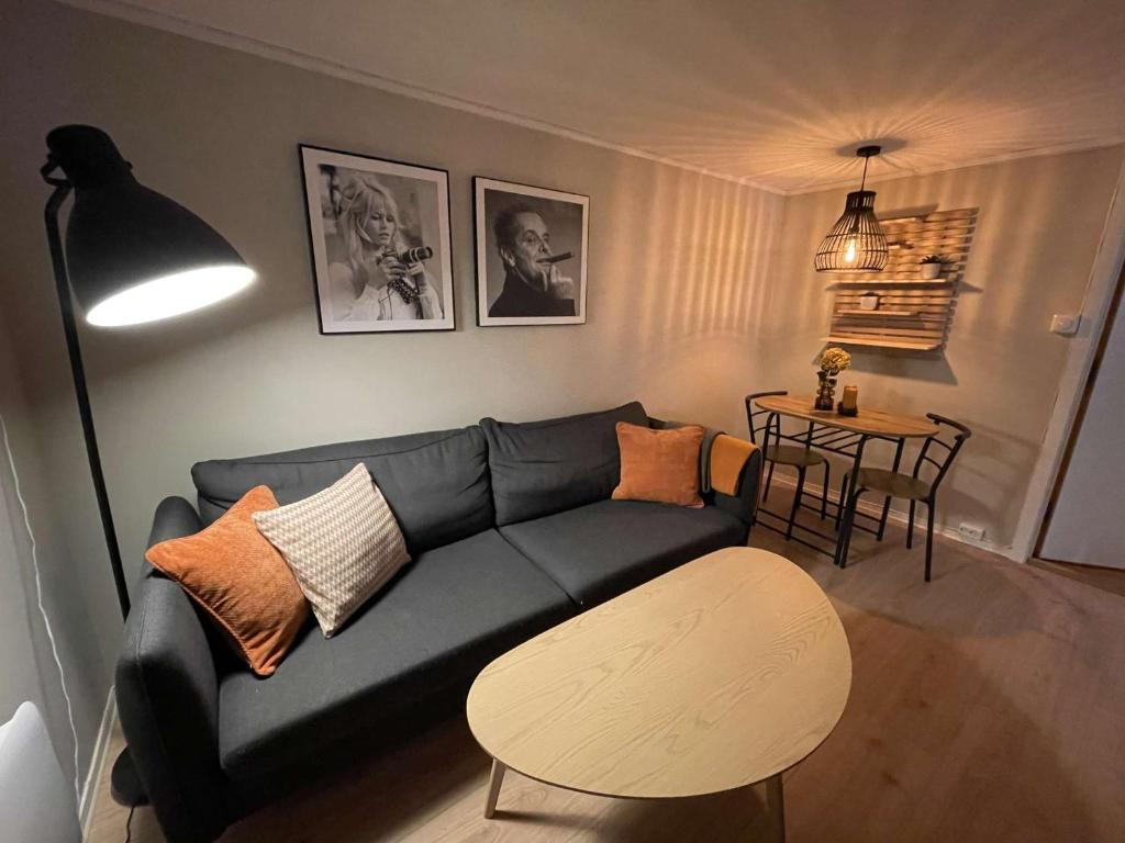 sala de estar con sofá azul y mesa en Apartment close to Aalesund center, en Ålesund