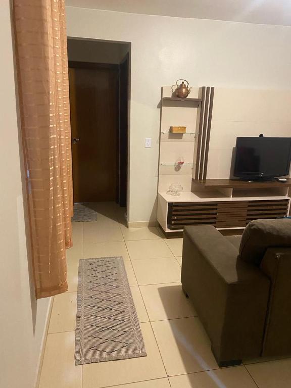 a living room with a couch and a tv at Samambaia QI 616 in Brasília