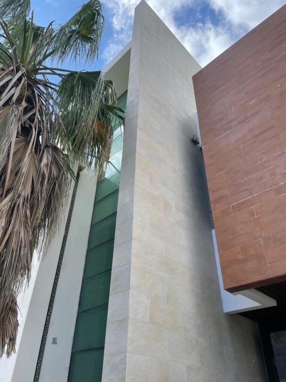 Un edificio con palmeras delante. en Casa para grandes Familias, en Cancún