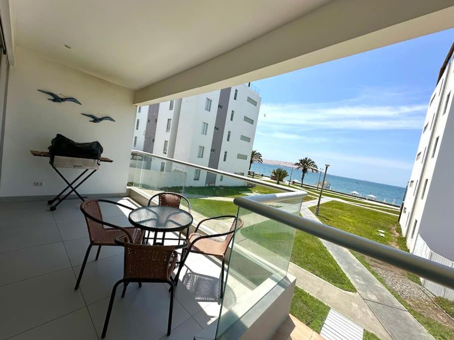 帕拉卡斯的住宿－VISTAMAR PARACAS Depa de playa la mejor vista，阳台配有桌椅,享有海景。