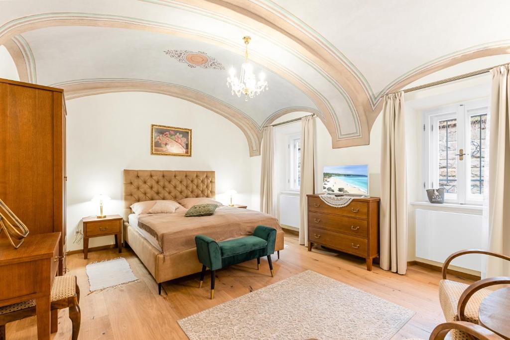a bedroom with an arched ceiling and a bed with a green chair at Apartmány sv. Floriána in Banská Štiavnica