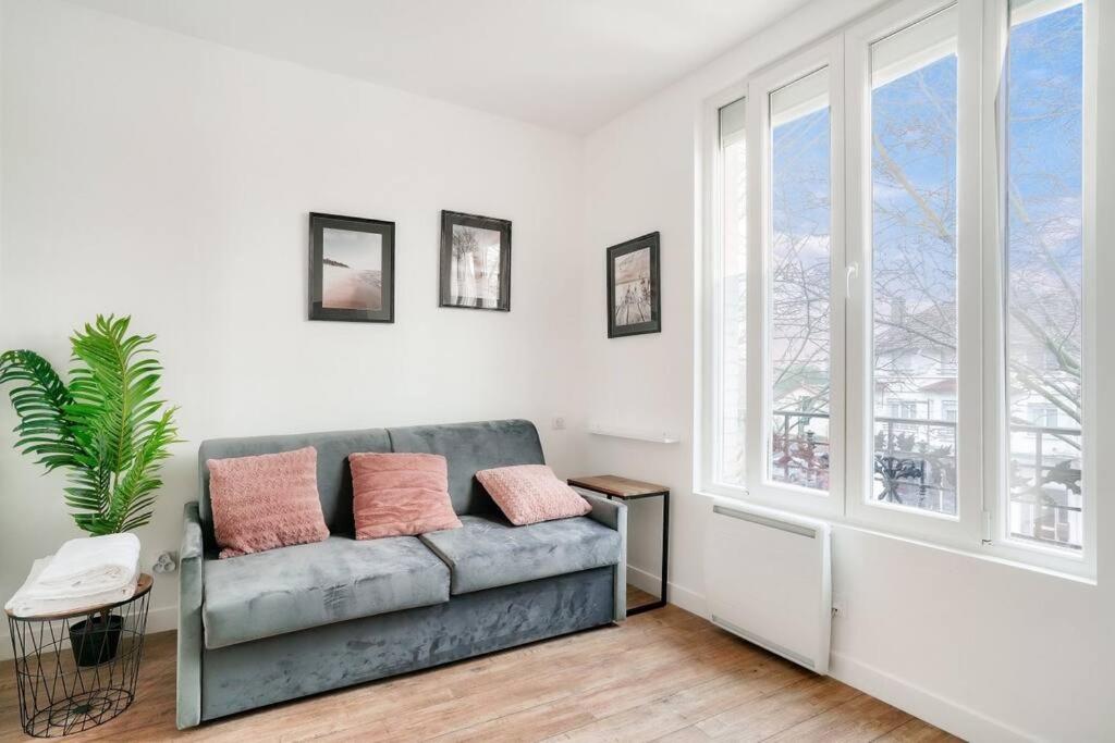 a living room with a couch and a window at Studette 4 calme et Lumineux, entièrement équipée in Créteil