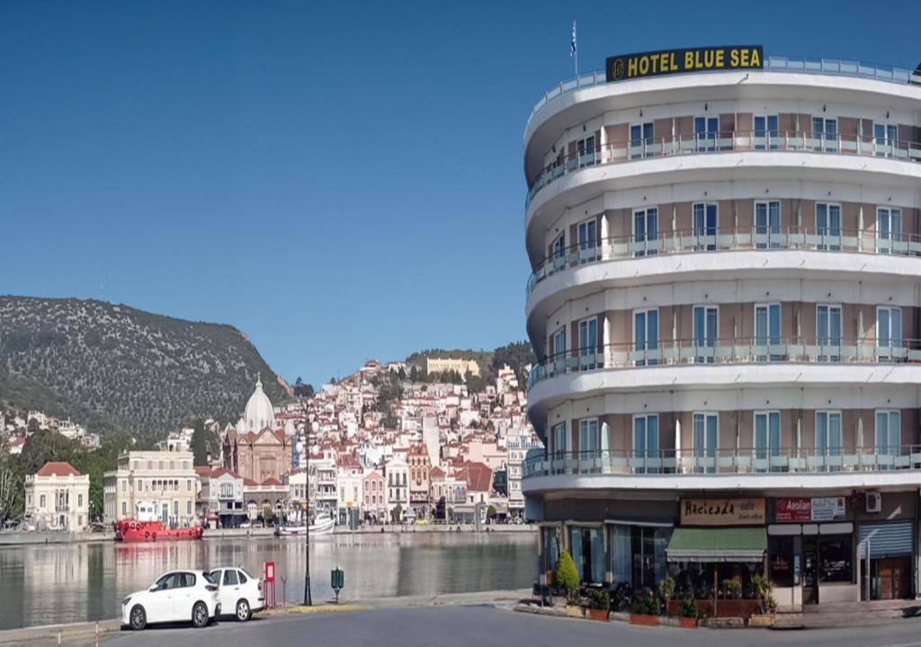 een witte auto geparkeerd voor een gebouw bij Blue Sea Hotel in Mytilini