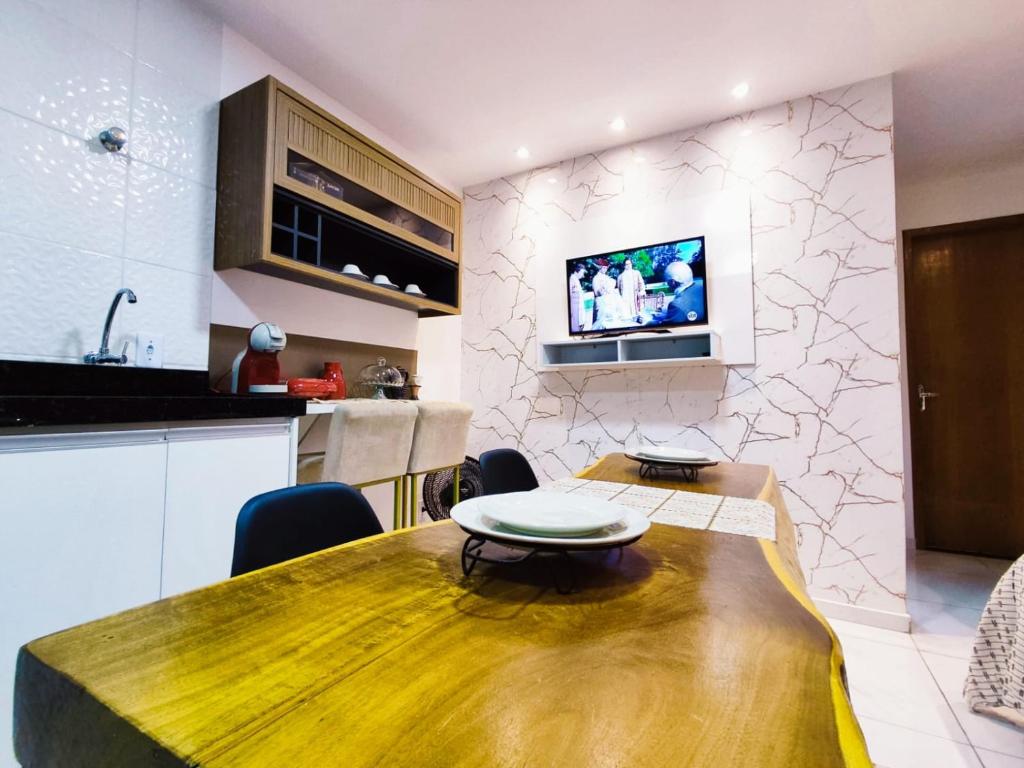 a kitchen and dining room with a wooden table at Studio luxuoso a 700 metros da praia. Vila Velha ES in Vila Velha