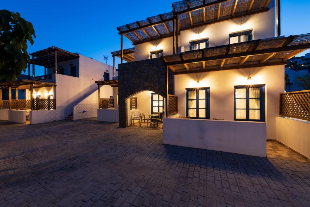 a large white house with a courtyard at night at Almiriki Serifos in Livadakia