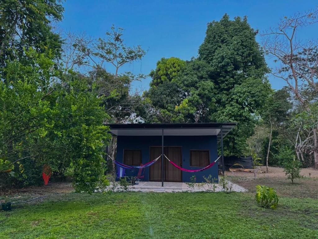 een klein blauw huis met een rood en blauw spandoek bij Deer House Cabuya in Cabuya