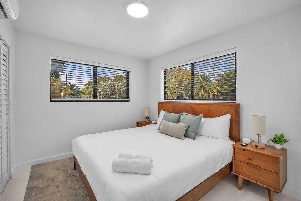 - une chambre blanche avec un grand lit et 2 fenêtres dans l'établissement Villa Roads Family Home 2 Beds 1 Bath, à Miami
