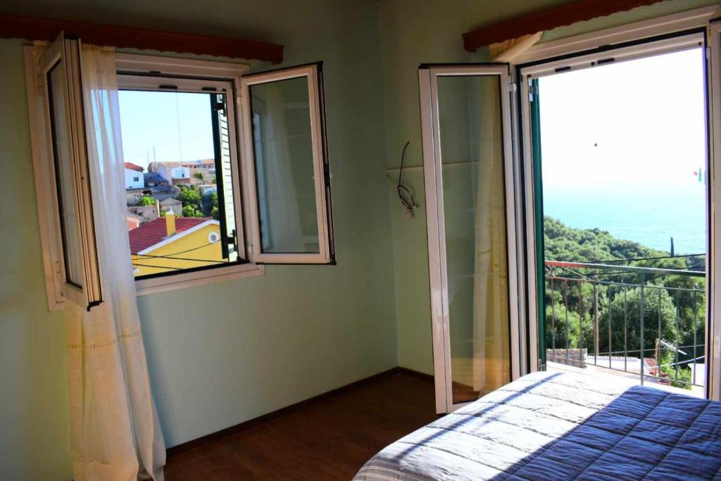 a bedroom with two windows and a bed with a view at Ostriche House in Pentátion