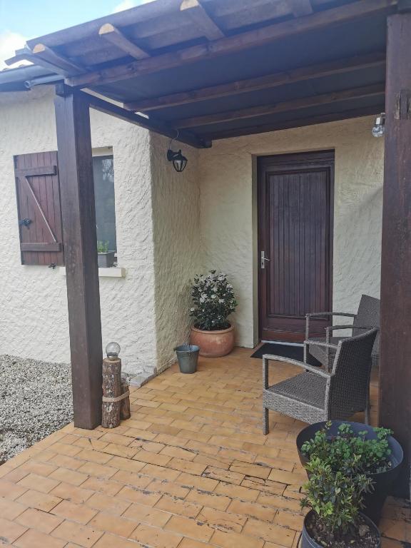 d'une terrasse avec une chaise et une porte en bois. dans l'établissement Studio à la campagne, à Champagné-Saint-Hilaire