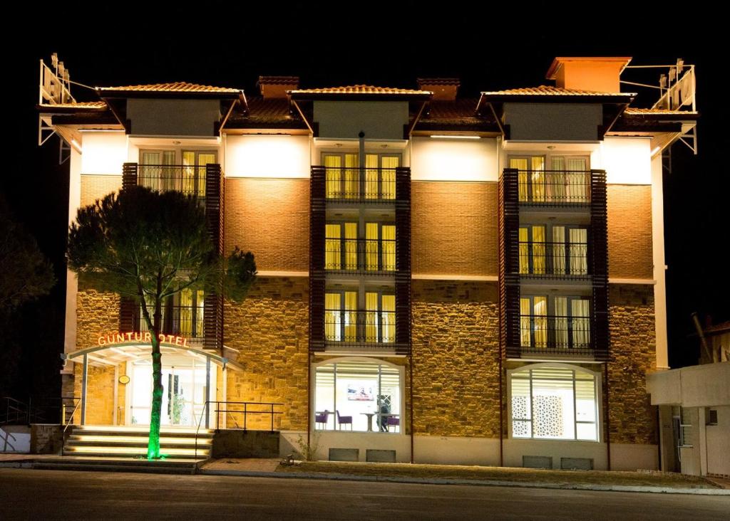 a large brick building with a green light at GÜNTURPARK OTEL in Beylerbeyi