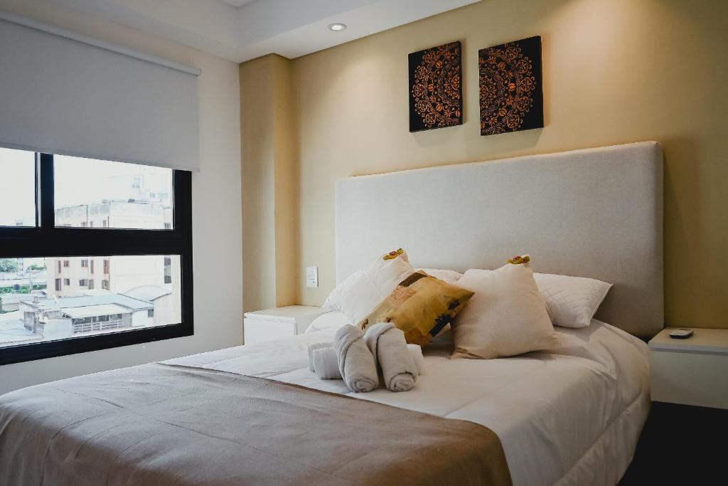 sypialnia z dużym łóżkiem z dwoma ręcznikami w obiekcie Alcazar Suites Deluxe w mieście Salta