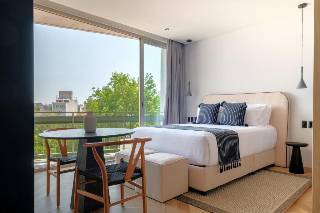 a bedroom with a bed and a table and a window at Casa Cibeles by Lumina in Mexico City