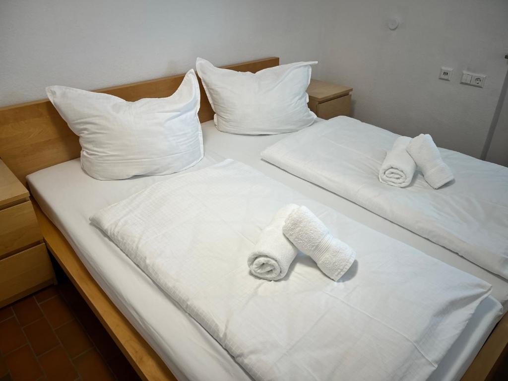 uma cama com duas toalhas e duas almofadas em Premium Apartment 70qm 2,5 Zimmer Küche, Smart TV, Garage, WiFi em Heidenheim an der Brenz