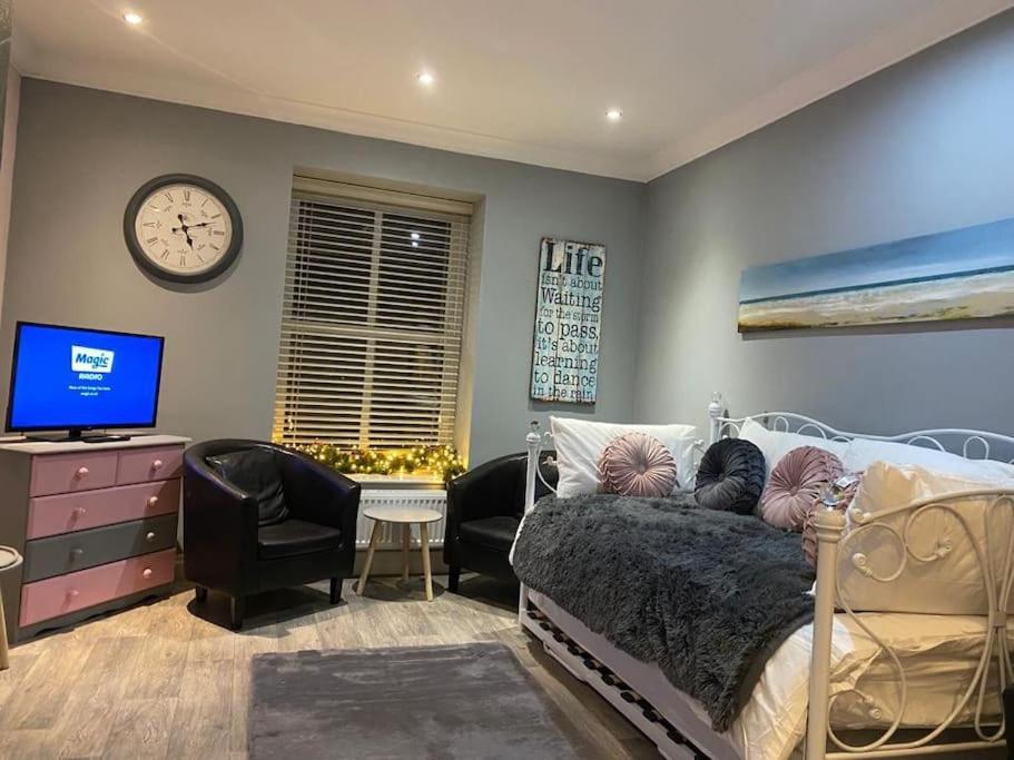 een slaapkamer met een bed en een tv en een klok bij 3 x Double Bedroomed Apartment, Snaith in Snaith