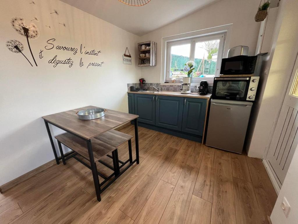 cocina con armarios azules y suelo de madera en le chalet du bonheur, en Liessies
