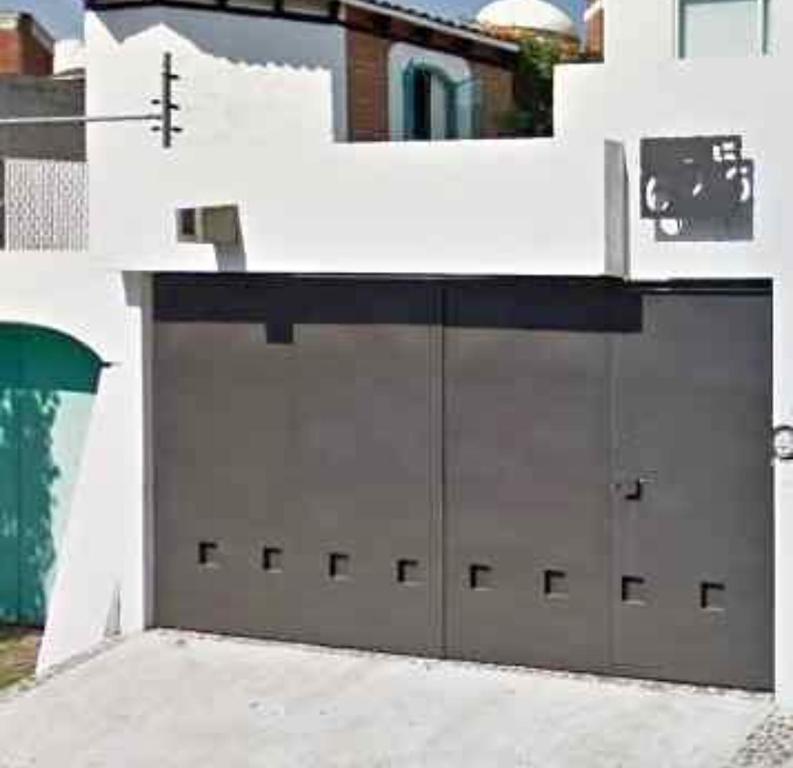 a white building with two garage doors in front at Casa milito bonito in Morelia