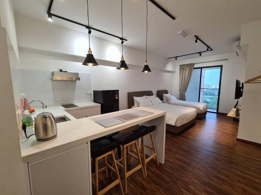 een keuken en een woonkamer met een bed in een kamer bij KaMi Homestay (2-3pax)/国际机场5分钟 in Donggongon