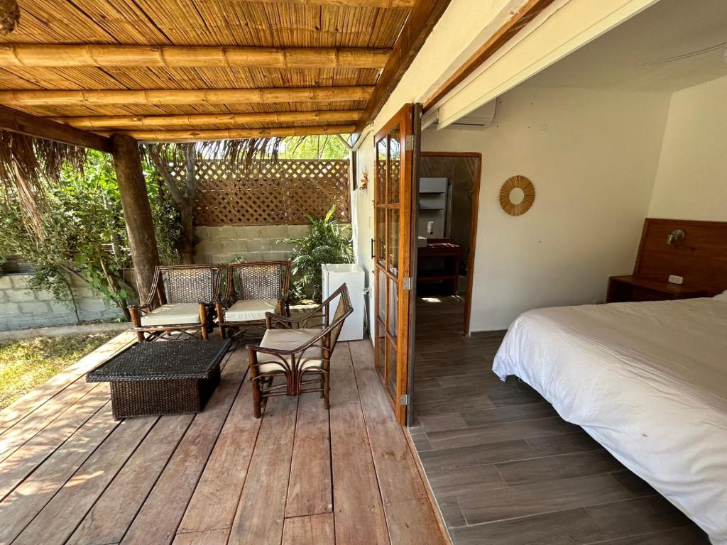 a wooden deck with a bed and chairs on it at Casa Canoa in Canoas