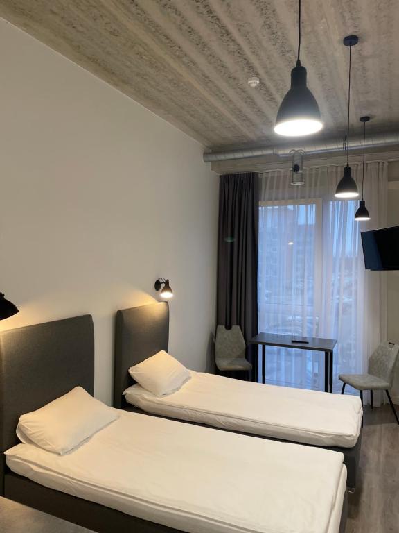 um quarto de hotel com duas camas e uma mesa em Apartment Loftas13-6 em Kretinga