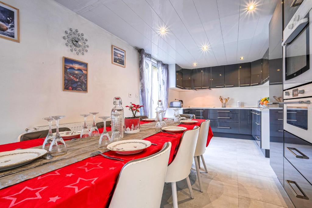 uma sala de jantar com uma mesa vermelha e cadeiras em Maison spacieuse de 100m2 avec 3 chambres et jardin à 10 min à pied de la gare de meaux, 20 min de Disney et 30 min de paris em Villenoy