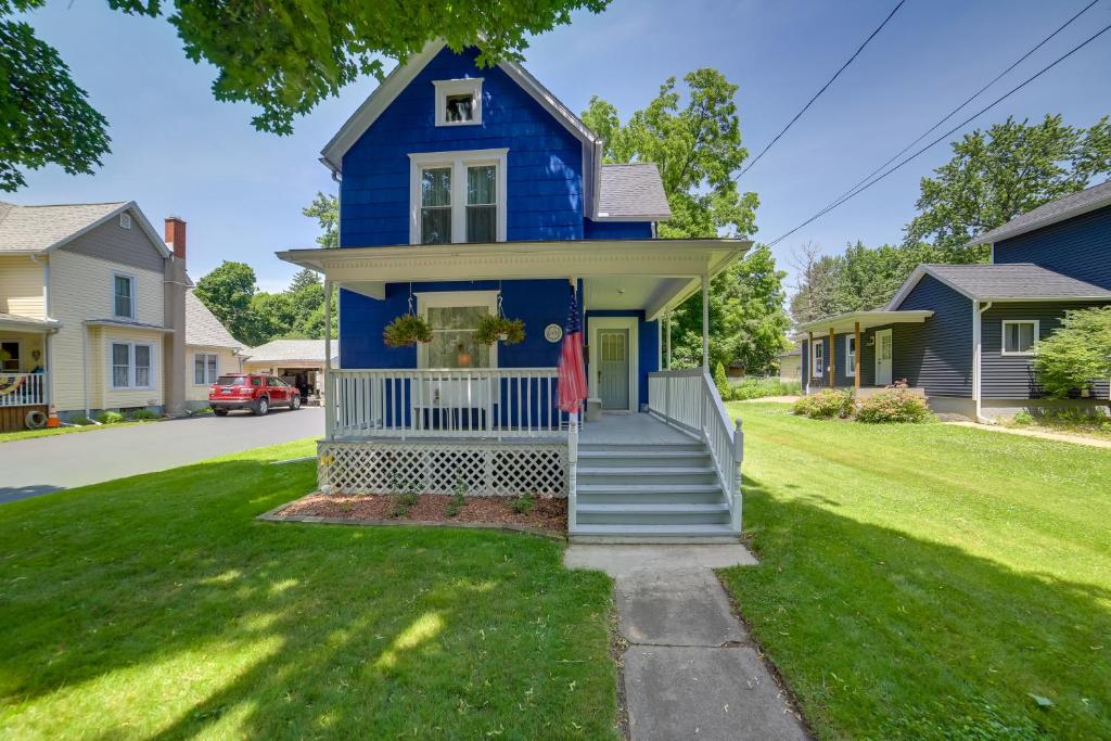 een blauw huis met een persoon op de veranda bij Family-Friendly Home Less Than 1 Mi to Adrian College in Adrian