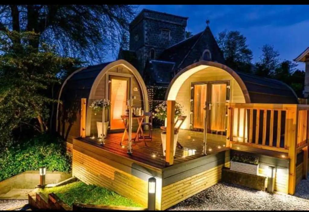 una casa pequeña con terraza frente a una casa en Loch View Luxury Pod, en Connel