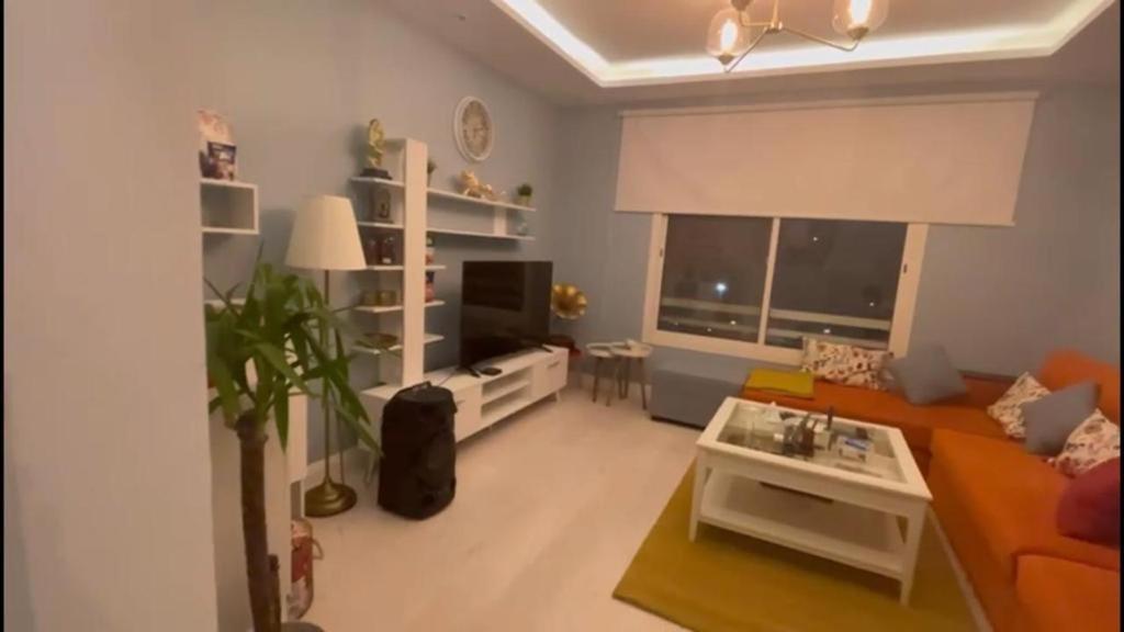 a living room with a couch and a tv at Happiness Place in King Abdullah Economic City