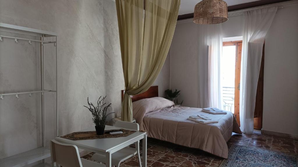 a bedroom with a bed and a table and a window at Palazzo montagna in Grotte