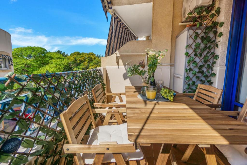 a balcony with a wooden table and chairs at A spacious and cozy apartment. in Torrevieja