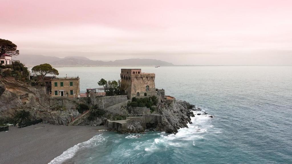 an old building on a cliff next to the ocean at Il Sogno in Erchie