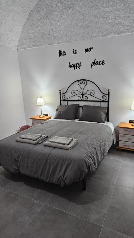 a bedroom with a bed with a happy place sign on the wall at Cuevas CEMAR in Guadix