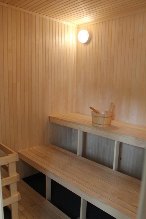 a sauna with wooden shelves and a light on the wall at Tromsø Lodge & Camping in Tromsø