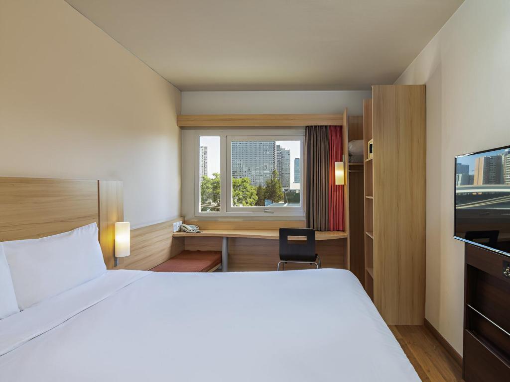 Una habitación de hotel con una cama y una ventana. en ibis Santiago Estacion Central, en Santiago