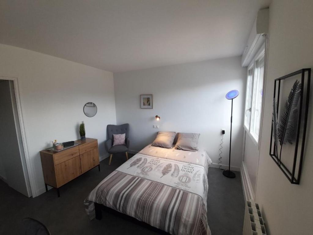 Schlafzimmer mit einem Bett, einem Schreibtisch und einem Stuhl in der Unterkunft Résidence du Léon in Landivisiau