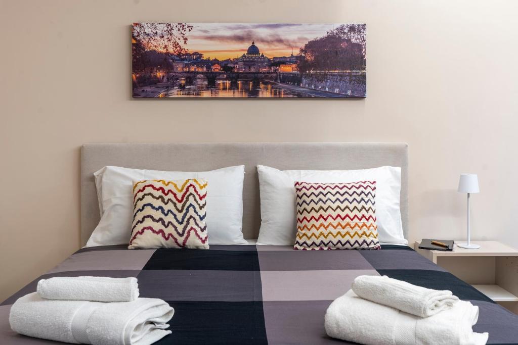 - une chambre avec un lit et des serviettes dans l'établissement Le stanze sui musei vaticani, à Rome