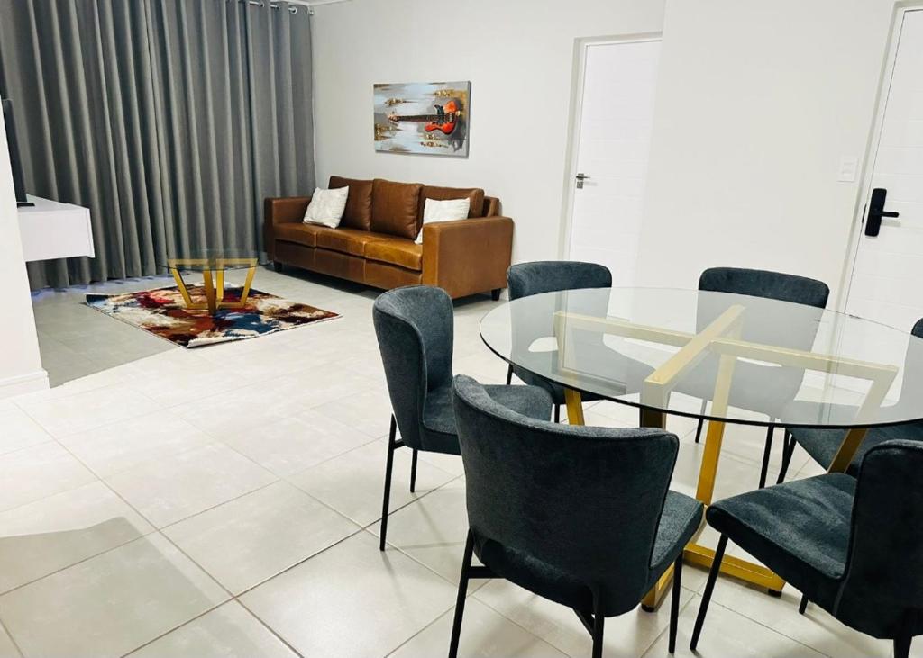 a living room with a glass table and chairs at Ballito Hills Lifestyle Estate in Ballito