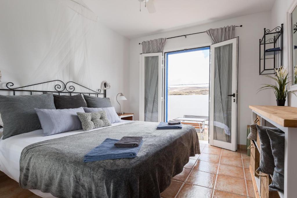 1 dormitorio con cama grande y ventana grande en Casa del Mar en Punta de Mujeres