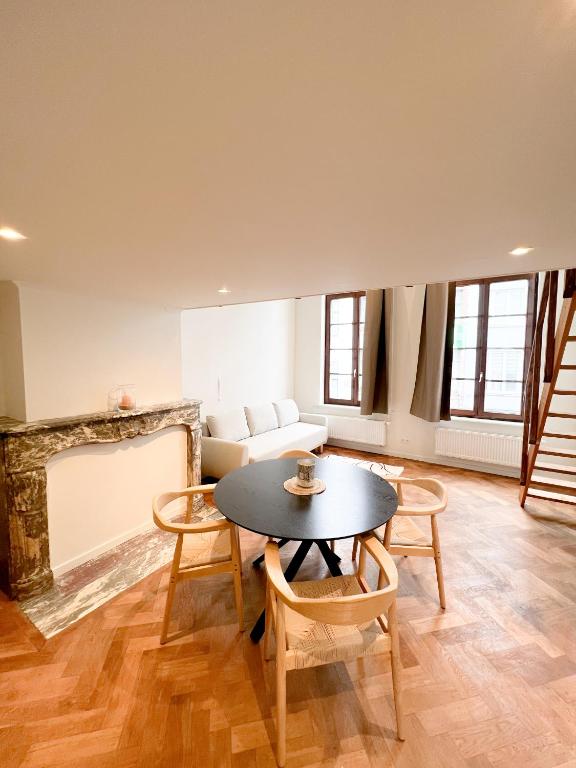 een woonkamer met een tafel en stoelen en een bank bij Mayfair Suites in Antwerpen