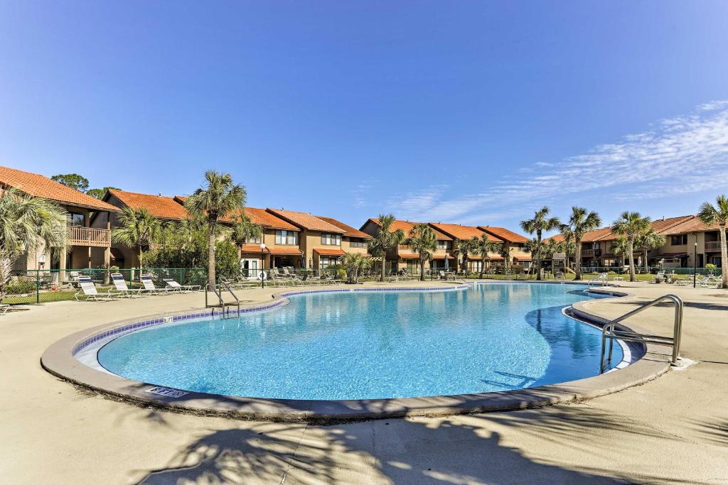 einen Pool in einem Resort mit Palmen und Häusern in der Unterkunft Panama City Beach Townhome with Resort Amenities! in Panama City Beach
