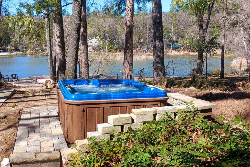 a hot tub sitting on a patio next to a lake at Two Canoe in Sonora