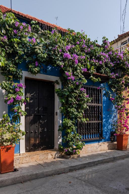 a blue building with purple flowers on it at Casa Familiar - Maria de las Palmas -Getsemani in Cartagena de Indias