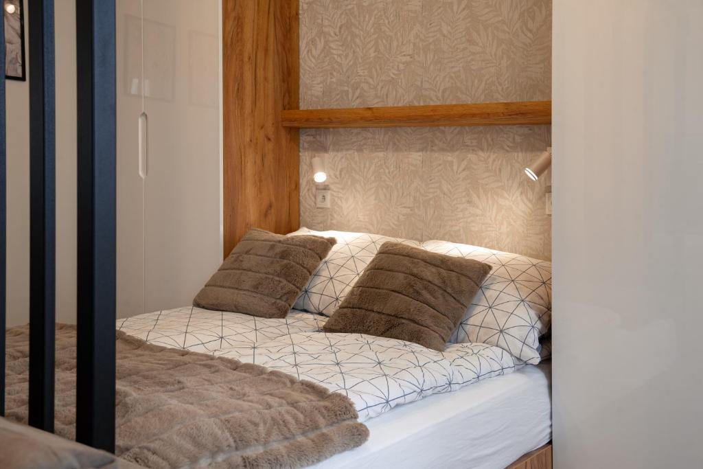 ein Bett mit braunen Kissen darüber in der Unterkunft Ekskluzywny apartament + garaż in Krakau