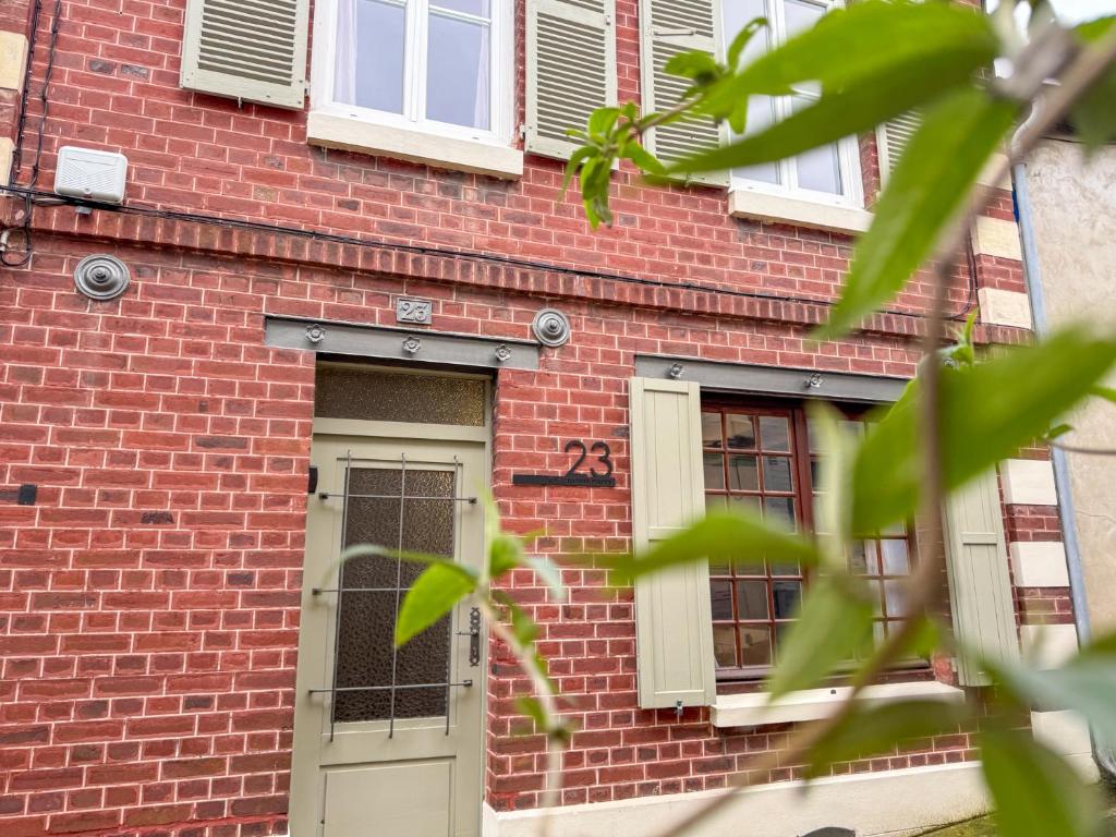 - un bâtiment en briques avec une porte et des fenêtres dans l'établissement Chez tonton Henri, maison de pêcheur, à Saint-Valery-sur-Somme