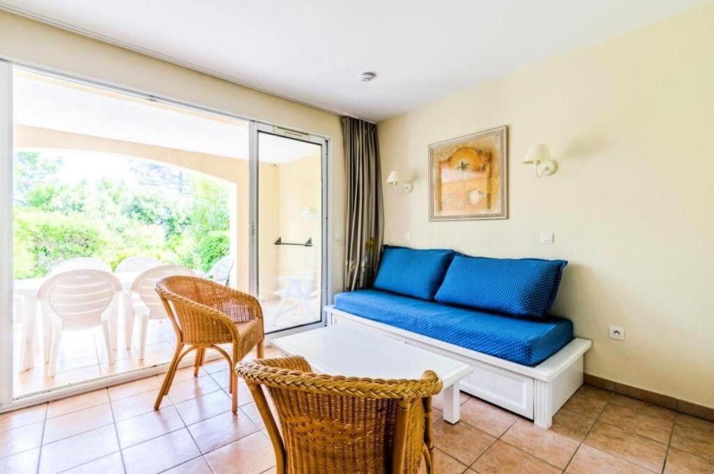 un salon avec un canapé bleu et un balcon dans l'établissement Résidence le Hameau des Issambres - maeva Home - Appartement 2 pièces 6 personnes - Sélection MAE-5684, aux Issambres