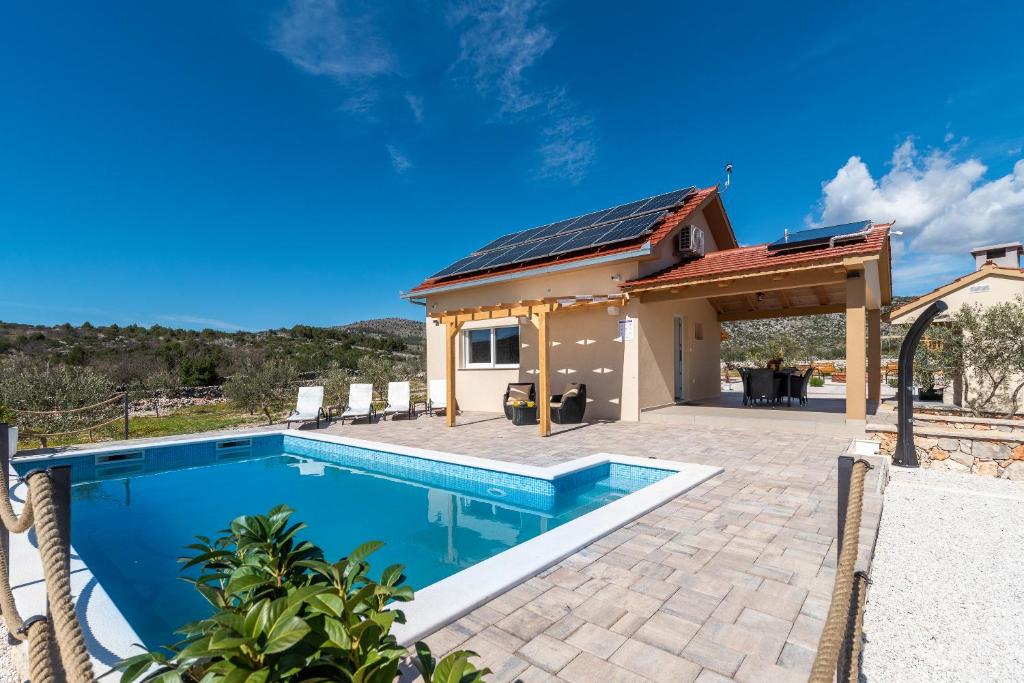 a villa with a swimming pool and a house at Holiday house OLIVE LAND in Gustirna