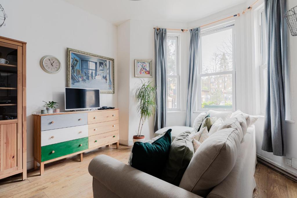 een woonkamer met een bank en een tv bij Arty Escape in Central London - Zone 2 in Londen