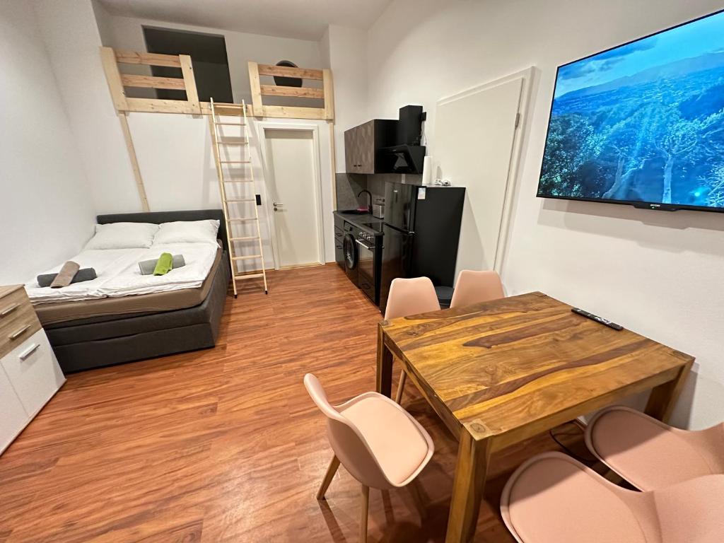 ein Wohnzimmer mit einem Bett, einem Tisch und Stühlen in der Unterkunft Cityflair Apartments Rummelsburg in Berlin
