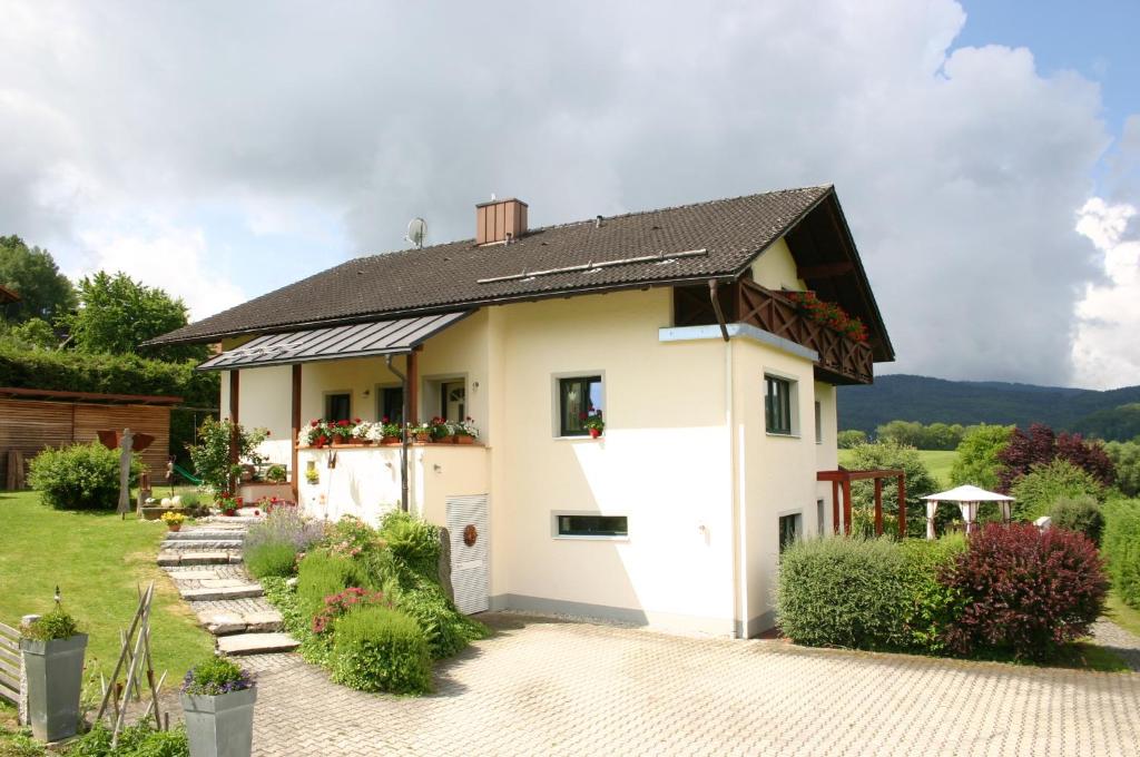 ein weißes Haus mit schwarzem Dach in der Unterkunft Pension Hoisl in Schönberg